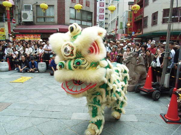 色鮮やかな獅子が南京町内の各店を回る「採青」