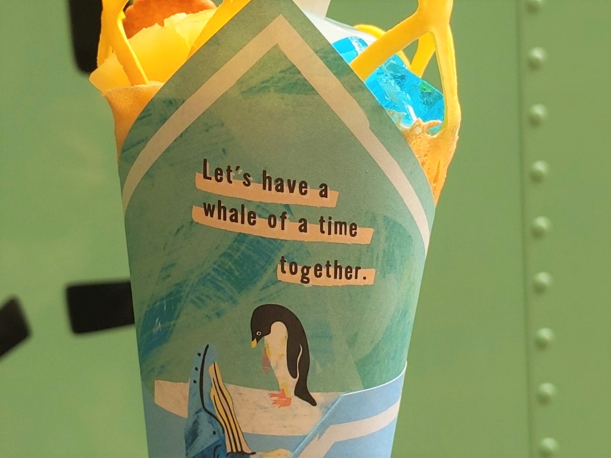 「ペンギンクレープ」限定の包み紙。アデリーペンギンとクジラが仲良くご対面しています