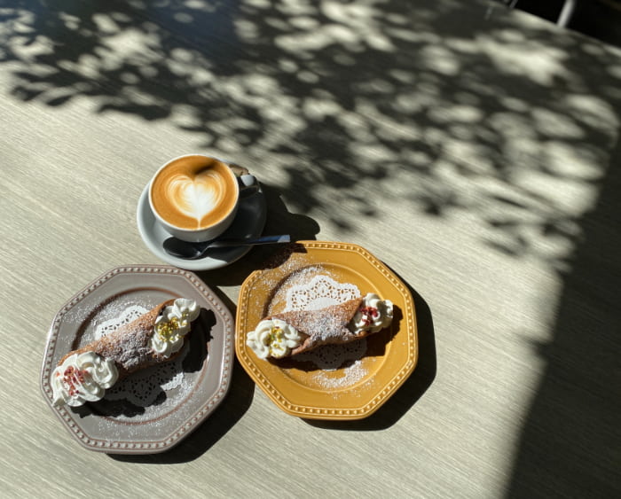 コーヒーと甘いお菓子はイタリアの朝食の定番。（上）「カプチーノ」550円（税込）、（左）「カンノーロ（ホイップクリーム）」550円（税込）、（右）「カンノーロ（リコッタチーズクリーム）」680円（税込）