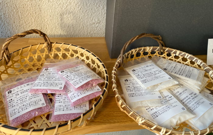 （左）秋田・男鹿半島の「桜塩」100円（税込）。桜の葉と紅大根エキスの自然なピンク色 
（右）与那国のサンゴから取れたカルシウムがたっぷりの「うるわしの花塩」100円（税込）