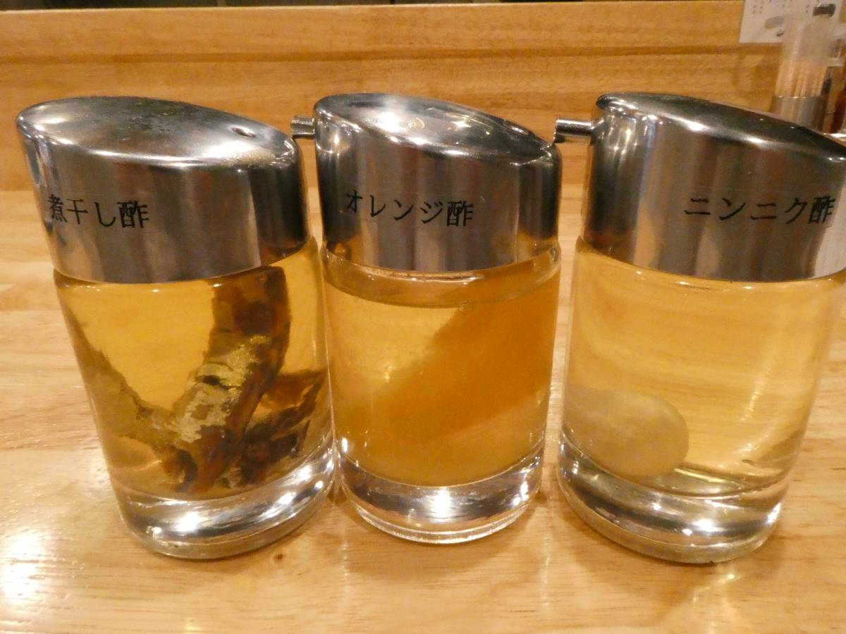 卓上に置いてあるお酢。（左から煮干し酢、オレンジ酢、ニンニク酢）