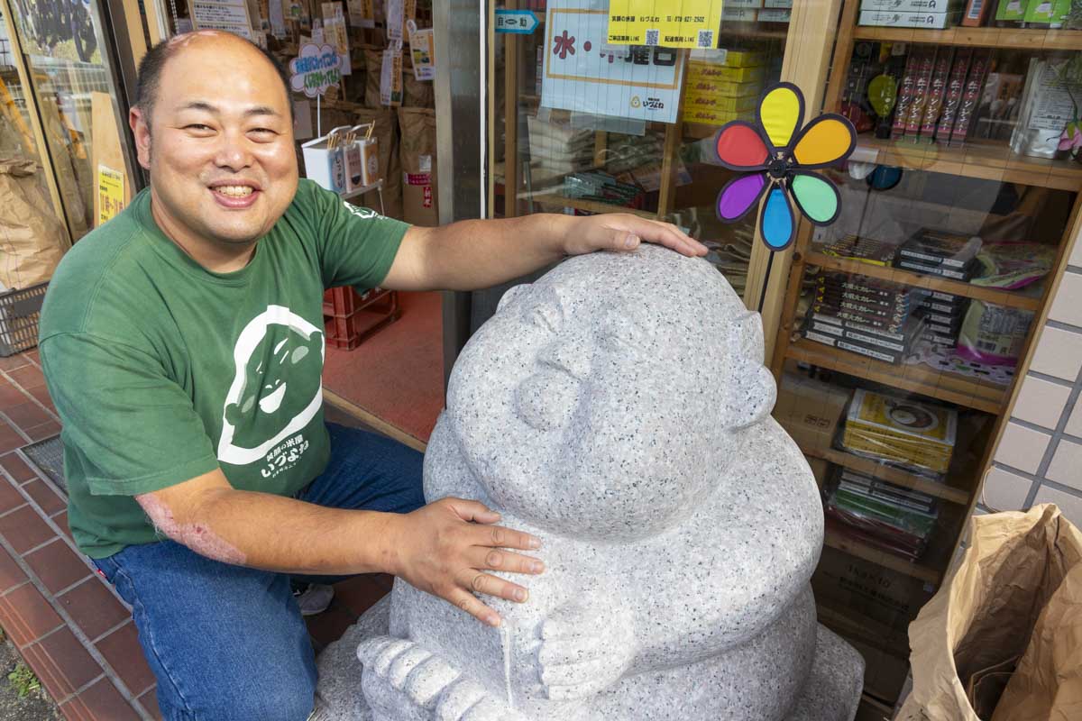 4代目店主の川崎さんと、川崎さんにそっくりの「いづよねさん」石像
